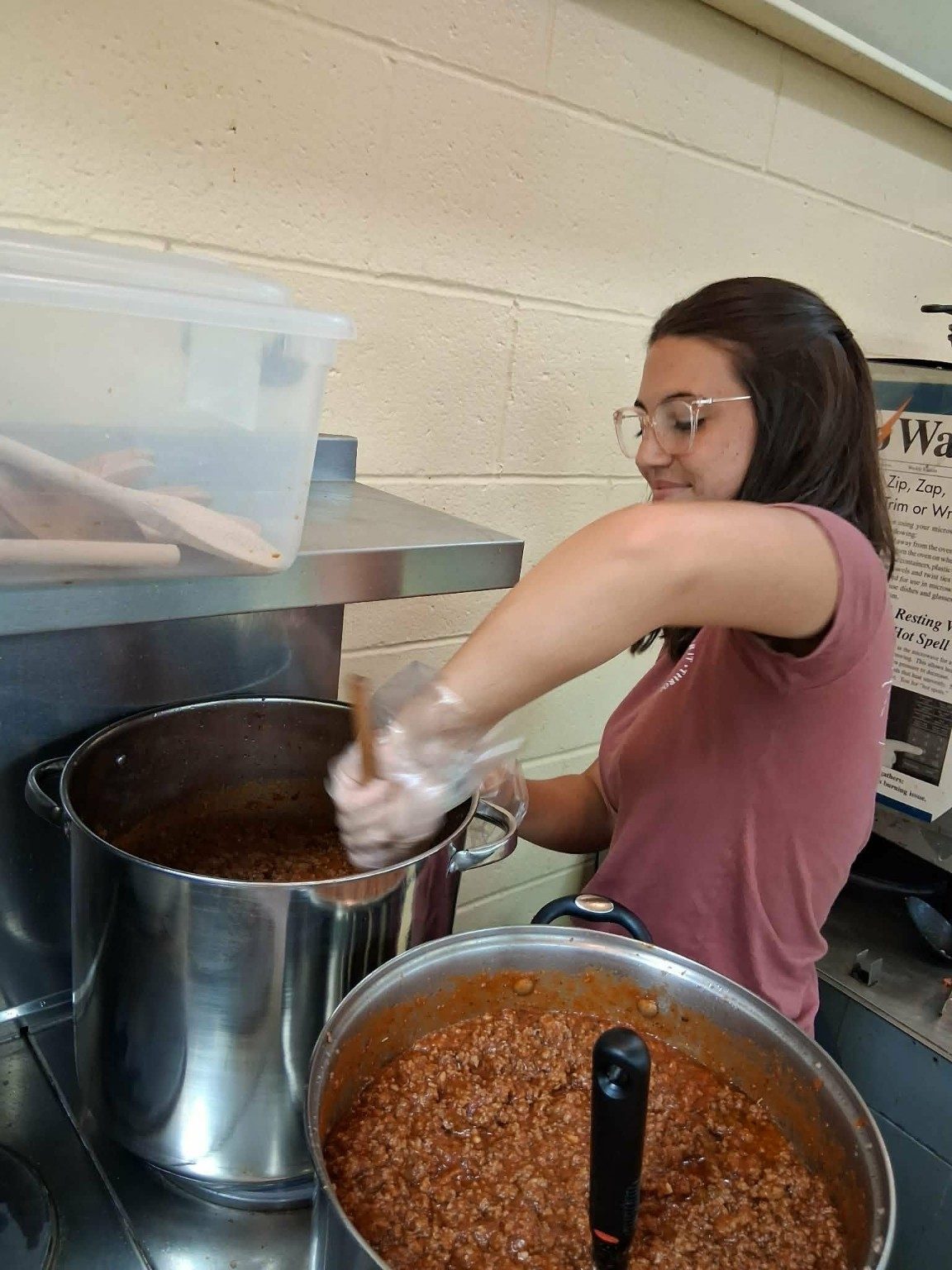 A LoveZagna volunteer preparing sauce