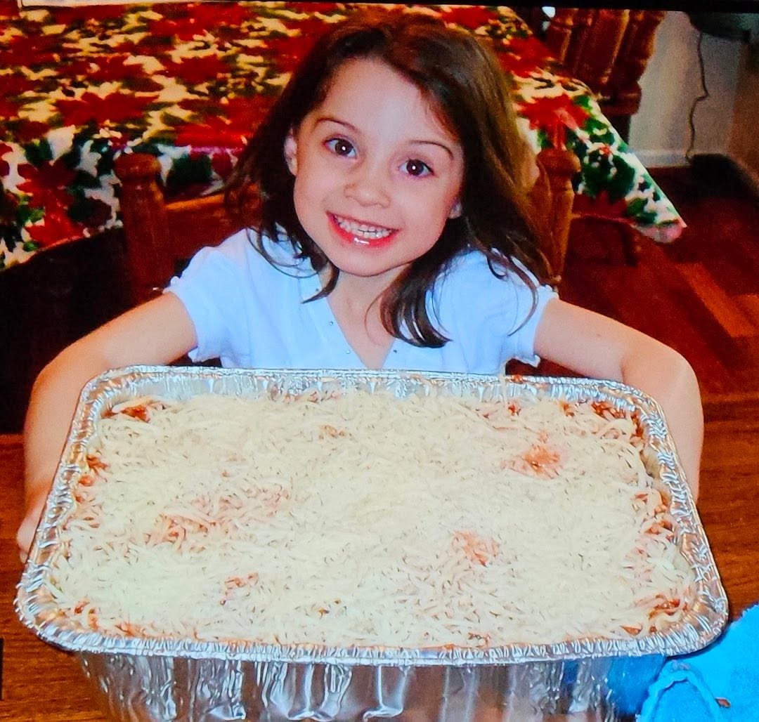 A young LoveZagna helper with a pan of lasagna